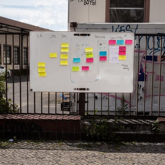 Großes Whiteboard an einem Zaun mit Post-its