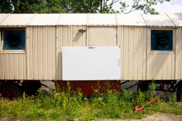 ein whiteboard an einen Bauwagen gehängt. Es zeigt, dass man auch im Freien arbeiten kann